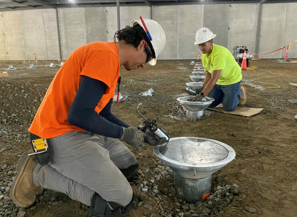 Construction workers build a 300,00 square foot facility